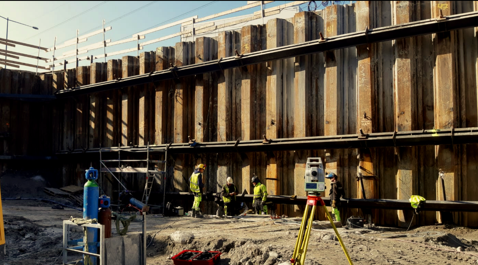 Surveying equipment and crew beside a retaining structure