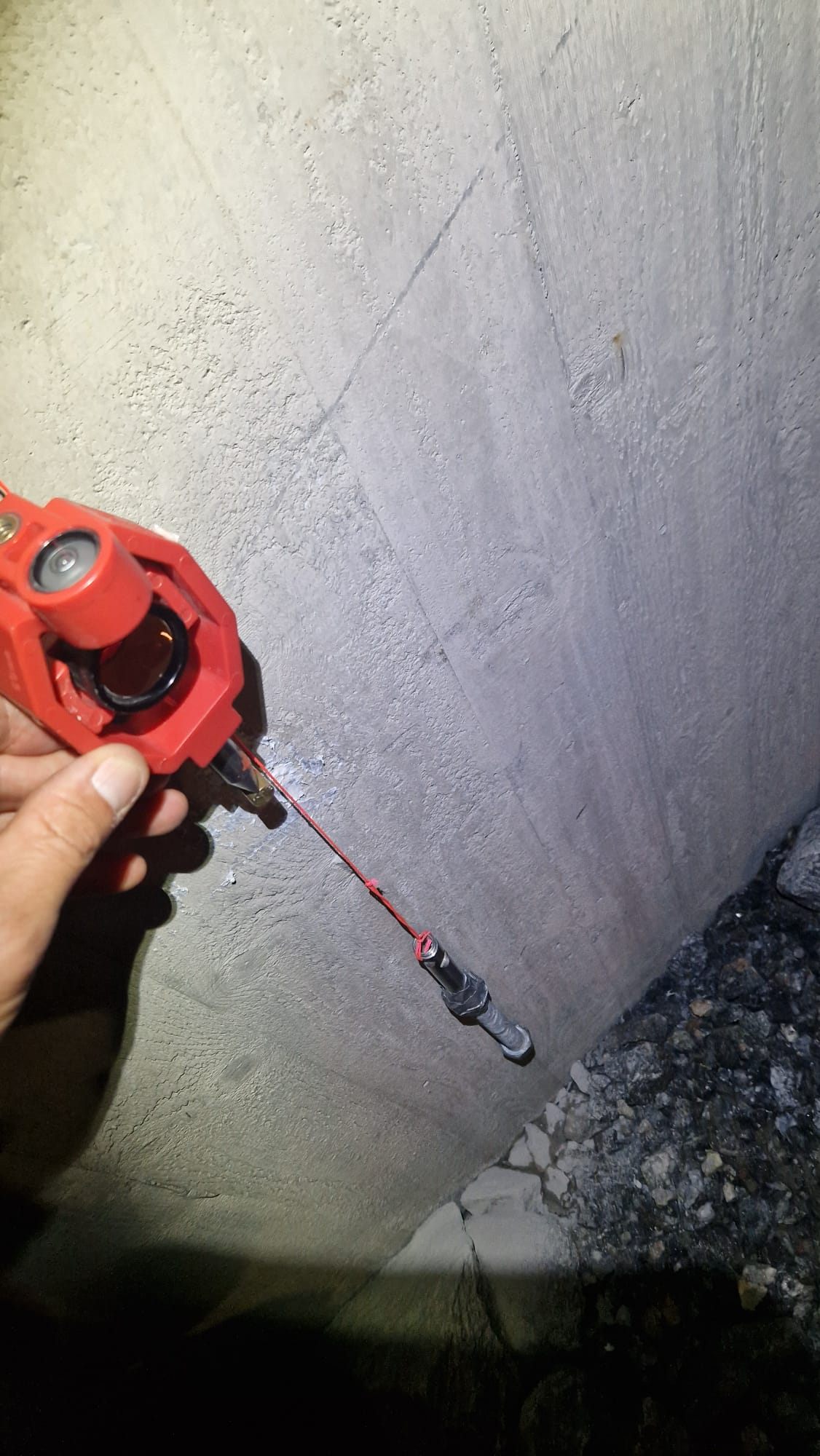 Surveying prism held against a concrete wall