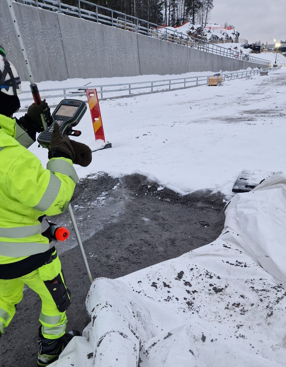 Surveyor using GNSS equipment in snowy conditions