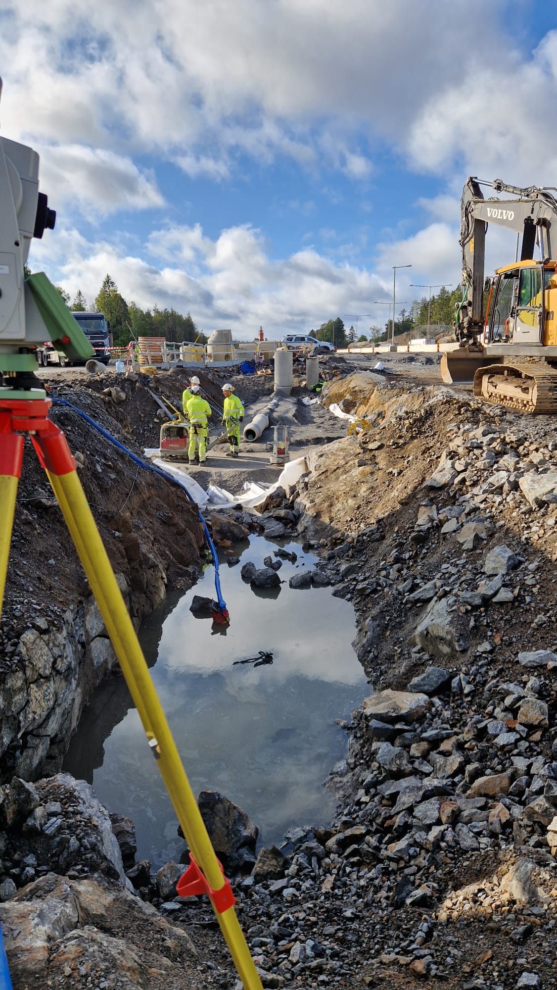 Total station in a rock excavation beside a pipe trench